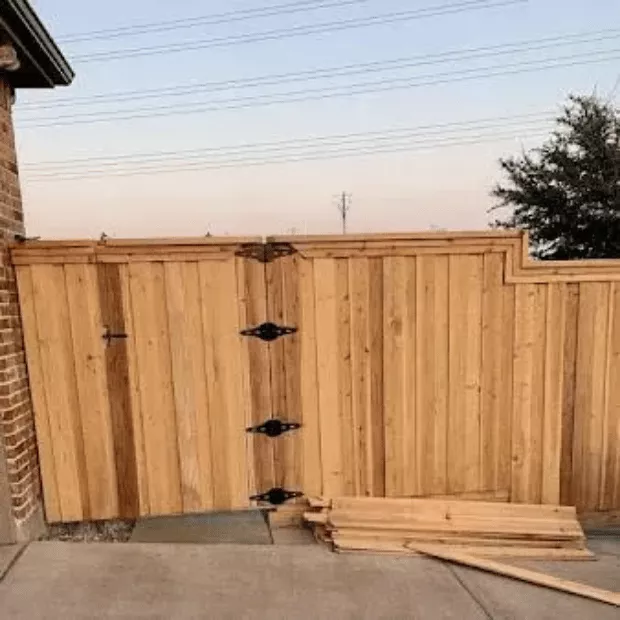 New cedar fence installation with double gate and decorative hardware