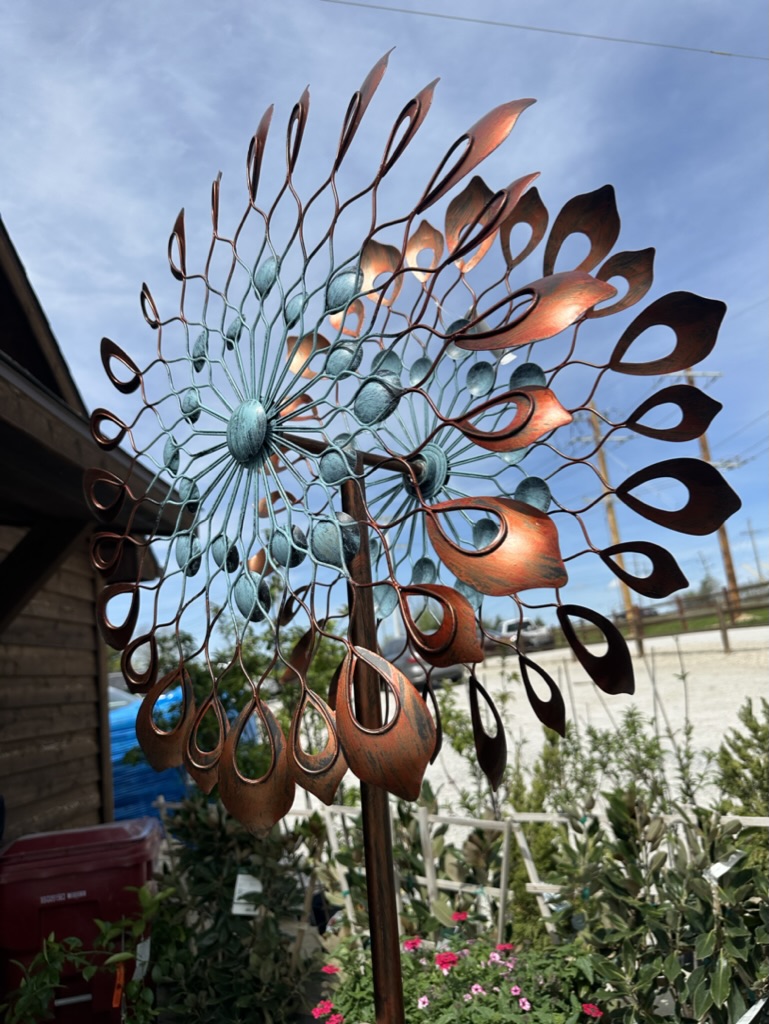 Decorative copper wind spinner installed in a finished landscape project