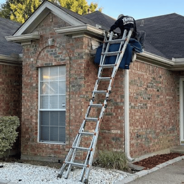 Trake technician on ladder performing gutter repair on a Rockwall residence