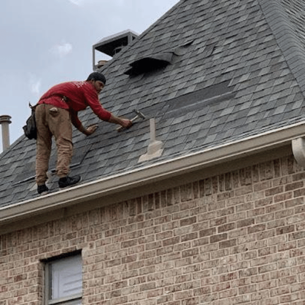 Roofing professional inspecting gutters and roof line on a Rockwall home