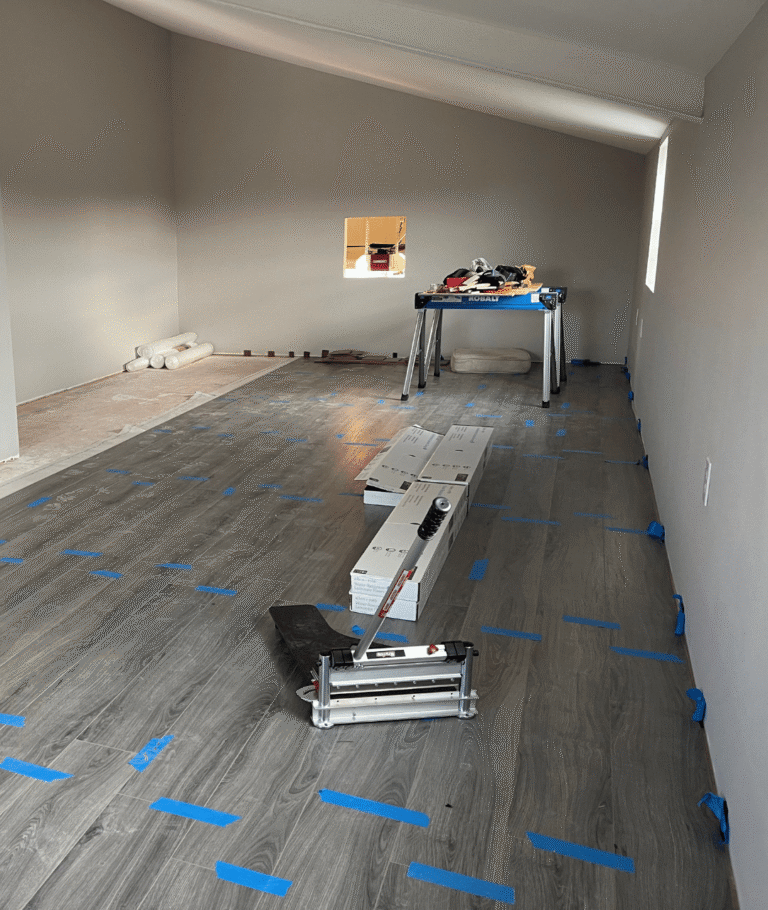 Man cave construction in progress with new vinyl plank flooring being installed