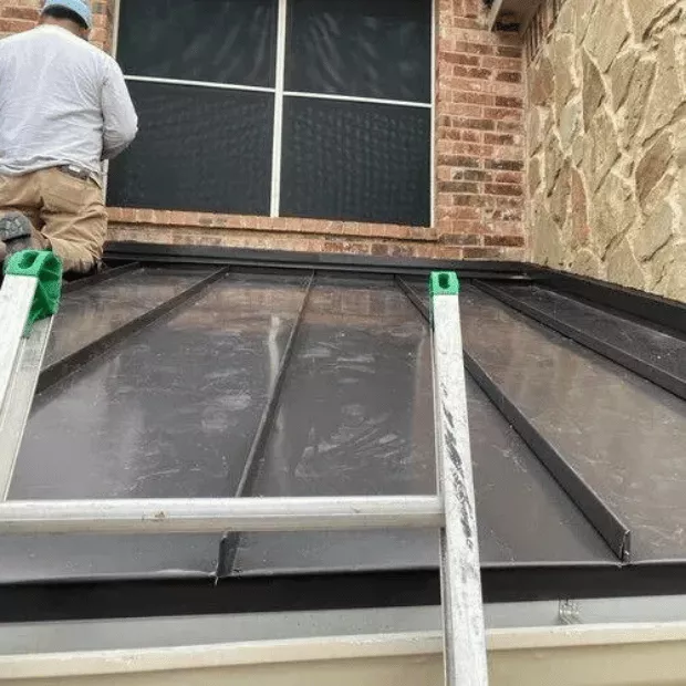 Technician inspecting and repairing standing-seam metal roof panels