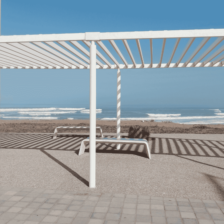 White louvered pergola installed at a commercial property providing shaded outdoor seating