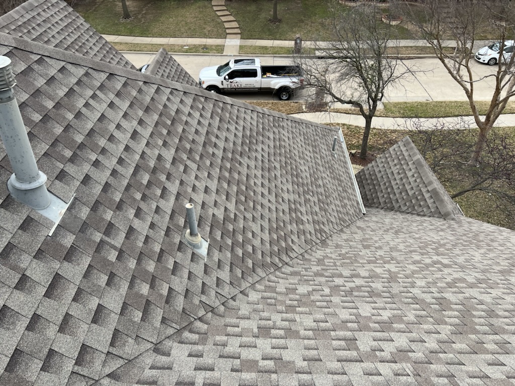 Storm-damaged shingles before and full shingle replacement after by Trake Construction — after