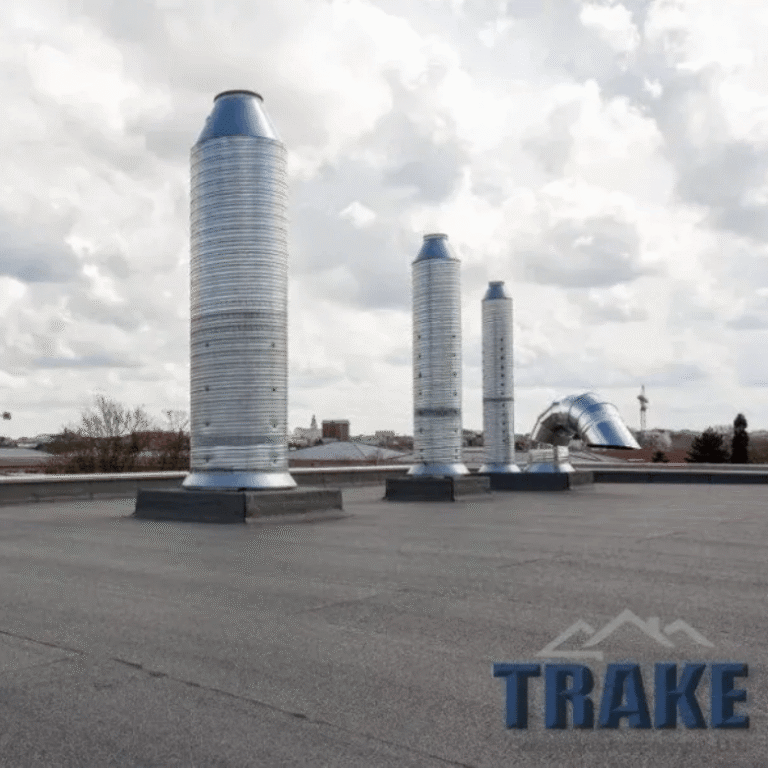 Commercial low-slope roof with metal exhaust stacks serviced by Trake Construction in Rockwall