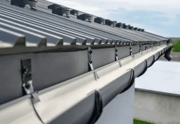 Standing-seam metal commercial roof edge with new gutter system installed