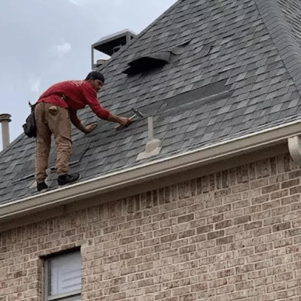 Trake roofer repairing storm-damaged shingles on a Rockwall residential roof